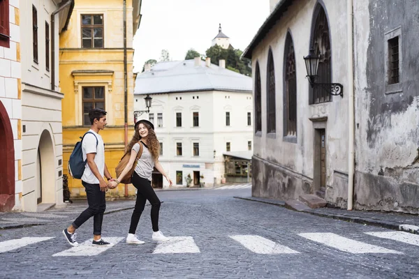 Two young tourists crossing the road in the old town. — Stock Photo, Image