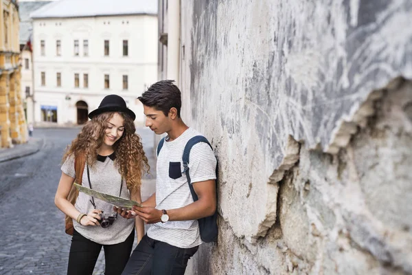 Dos jóvenes turistas con un mapa en el casco antiguo . — Foto de Stock