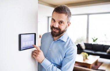 Bir tablet ile akıllı ev perde işaret eden bir adam.