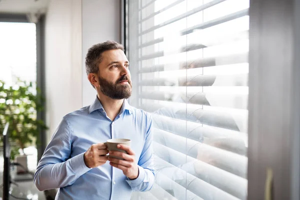 Un uomo vicino alla finestra con una tazza di caffe '. Casa intelligente . — Foto Stock