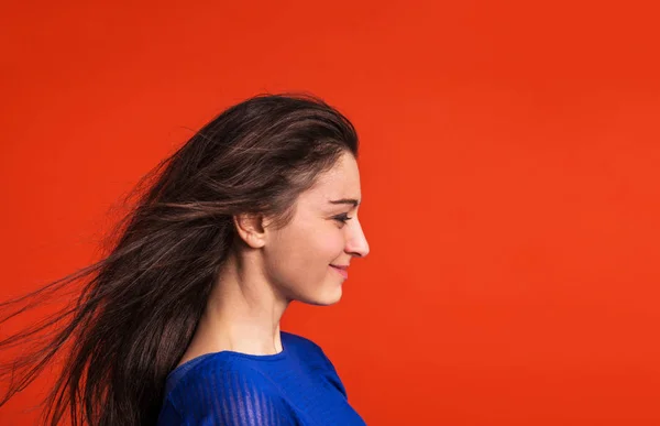 Una giovane donna in studio su uno sfondo rosso . — Foto Stock