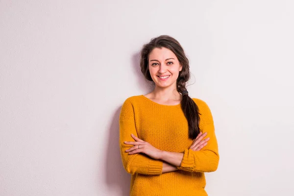 Eine junge Frau im Atelier vor grauem Hintergrund. — Stockfoto