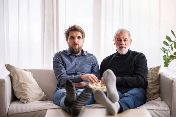 Hipster figlio e suo padre maggiore con computer portatile a casa . — Foto Stock