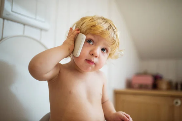 Söt liten knatte pojke med smartphone i badrummet. — Stockfoto