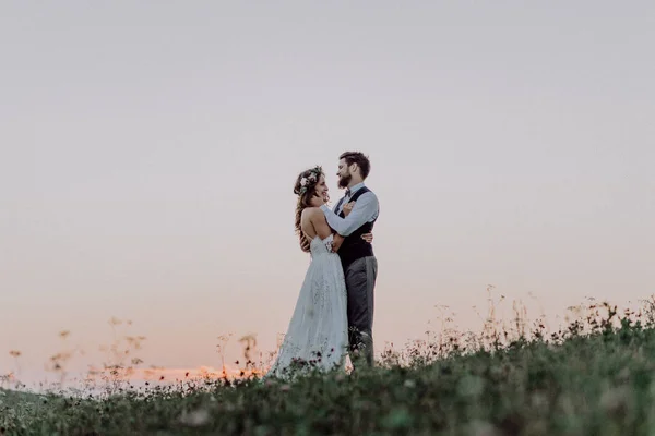 Beautiful bride and groom at sunset in green nature. — Stock Photo, Image