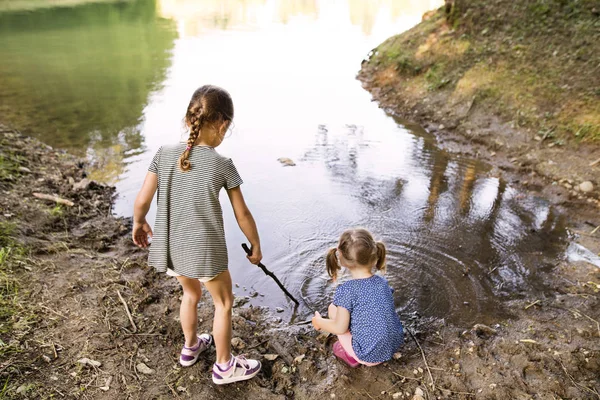 Κοριτσάκια που στέκεται στη λίμνη. Ηλιόλουστο καλοκαιρινό. — Φωτογραφία Αρχείου