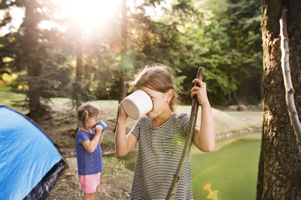 Meninas bonitos acampar ao ar livre, água potável . — Fotografia de Stock