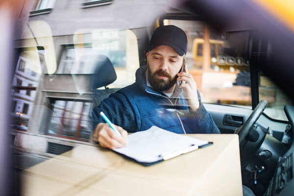 Delivery man with a parcel box in the car. — Stock Photo, Image
