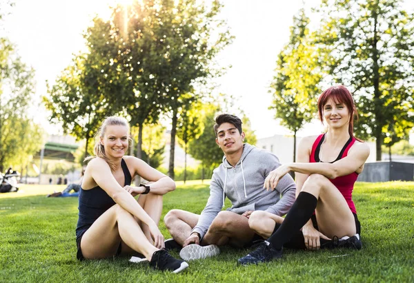 Group of young runners resting in a park. — Stock Photo, Image