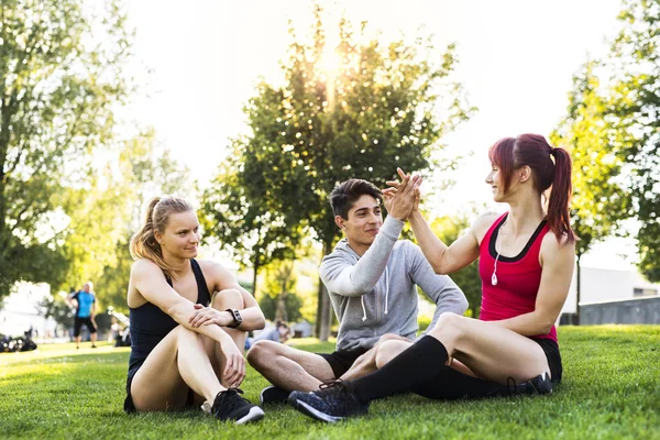 Groupe de jeunes coureurs se reposant dans un parc . — Photo