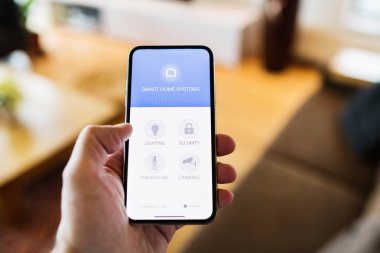 Bir smartphone akıllı ev perde ile tutan bir kadın.