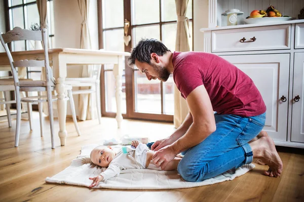 Ayah mengubah seorang bayi perempuan di rumah . — Stok Foto