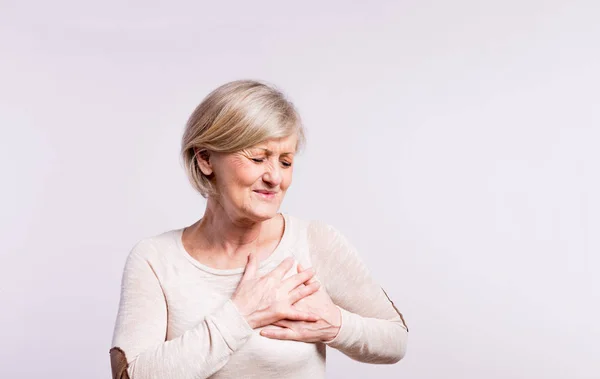 Studio portret van een senior vrouw in pijn. — Stockfoto