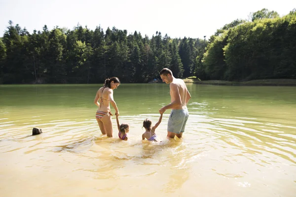 Mãe, pai e filhas no lago. Verão ensolarado . — Fotografia de Stock