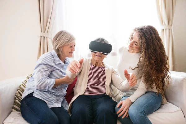 A teenage girl, mother and grandmother with VR goggles at home. — Stock Photo, Image