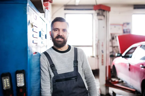 Porträtt av en man mekaniker i ett garage. — Stockfoto