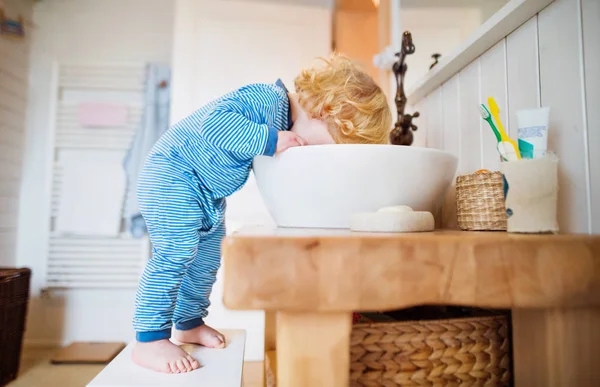 Toddler boy in a dangerous situation in the bathroom. — Stock Photo, Image