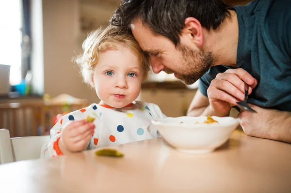 Padre alimentando a un niño en casa . —  Fotos de Stock