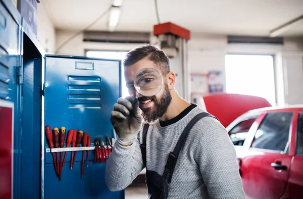 Портрет человека-механика в гараже, с помощью лупы . — стоковое фото
