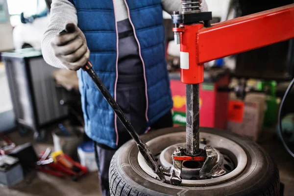 Hombre mecánico reparación de un coche en un garaje. —  Fotos de Stock
