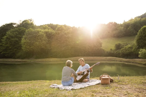 Äldre par vid sjön har picknick. — Stockfoto