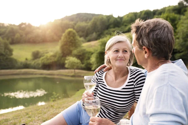 Pareja mayor en el lago haciendo un picnic . — Foto de Stock