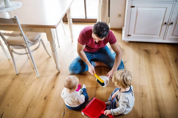 Padre y dos niños pequeños con cepillo y recogedor . — Foto de Stock