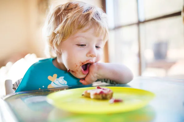 Un niño pequeño comiendo en casa . —  Fotos de Stock