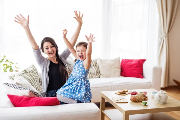 Jovem mãe com uma menina pequena em casa . — Fotografia de Stock