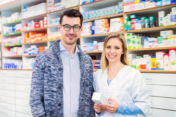 Retrato de mujer farmacéutica con un cliente varón . — Foto de Stock