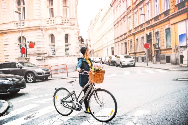 Mujer joven con bicicleta en la soleada ciudad de primavera . — Foto de Stock