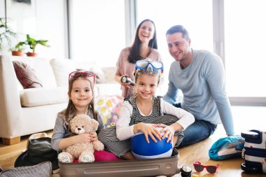 Tatil için ambalaj iki çocuklu genç aile.