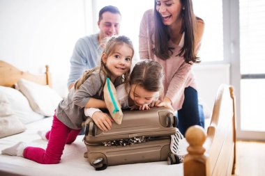 Tatil için ambalaj iki çocuklu genç aile.
