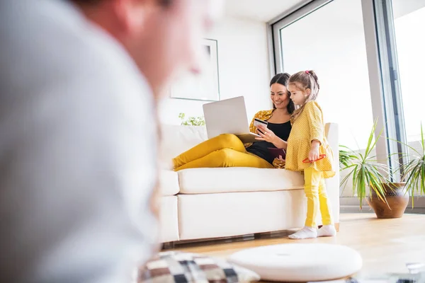 Familia joven con portátil que se prepara para las vacaciones . — Foto de Stock