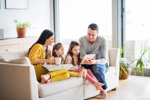 Famiglia giovane con due bambini e tablet che si prepara per le vacanze . — Foto Stock