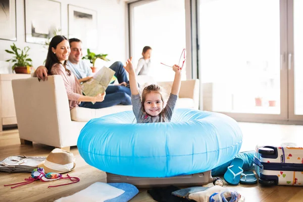 Familia joven con dos niños empacando para vacaciones . — Foto de Stock