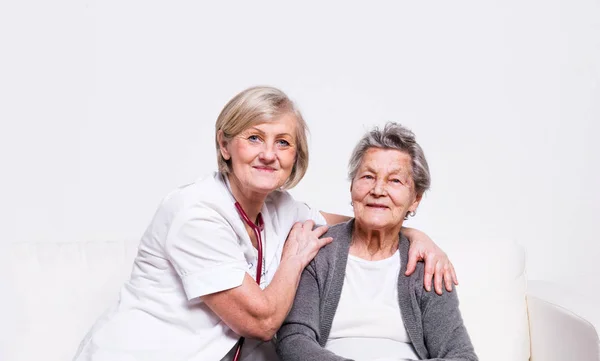 Studioporträt einer Altenpflegerin und einer älteren Frau. — Stockfoto
