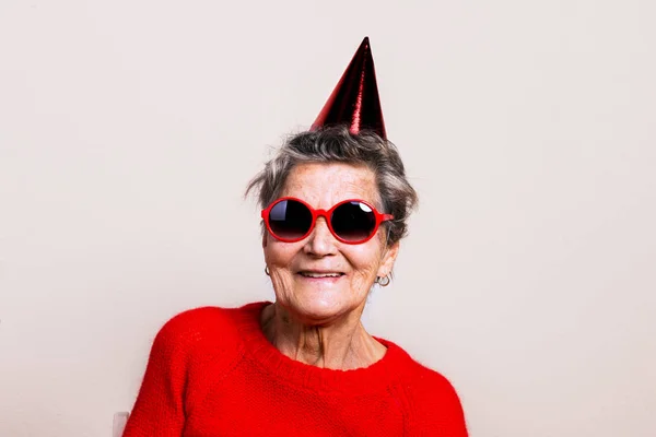 Portrait of a senior woman in studio. Party concept. — Stock Photo, Image
