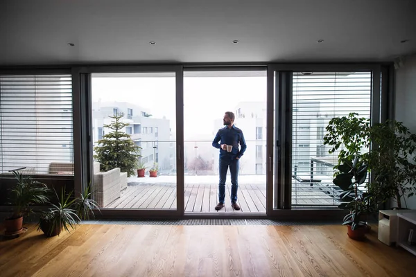 Bir adam bir fincan kahve evde tutan bir balkon. — Stok fotoğraf