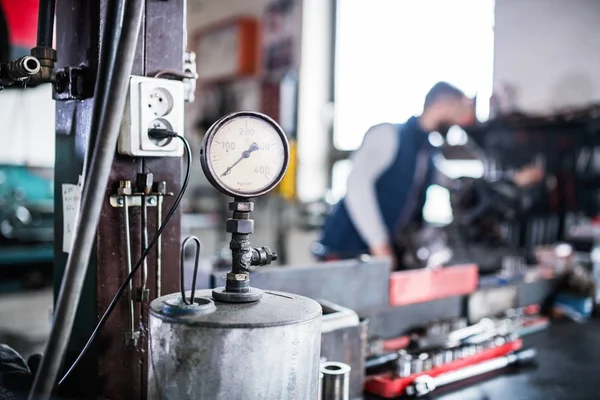 Hombre mecánico reparación de un coche en un garaje. —  Fotos de Stock