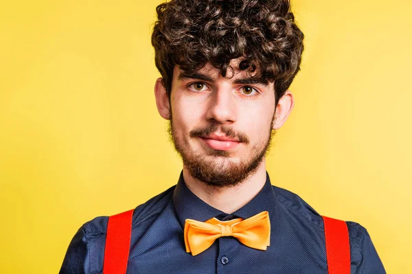 Portret van een jonge man in een studio op een gele achtergrond. — Stockfoto