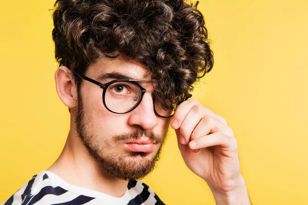 Studio portret van een jonge man een gele achtergrond. — Stockfoto