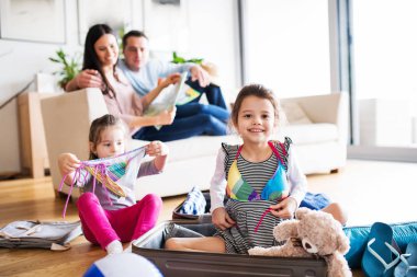 Tatil için ambalaj iki çocuklu genç aile.