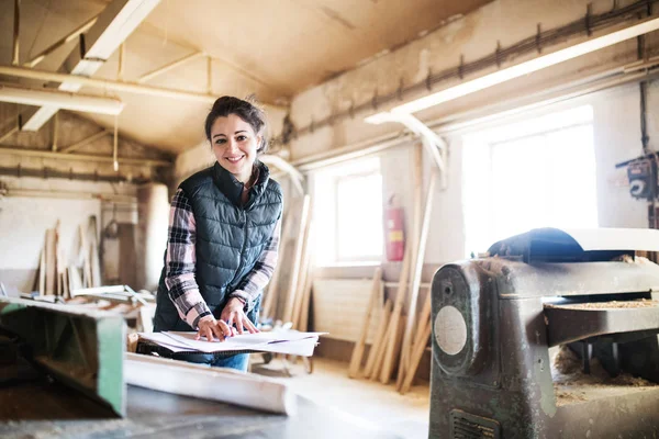 Retrato de una mujer trabajadora en el taller de carpintería . — Foto de Stock