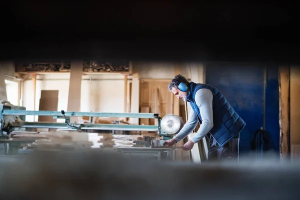 Un hombre trabajador en el taller de carpintería, trabajando con madera . —  Fotos de Stock