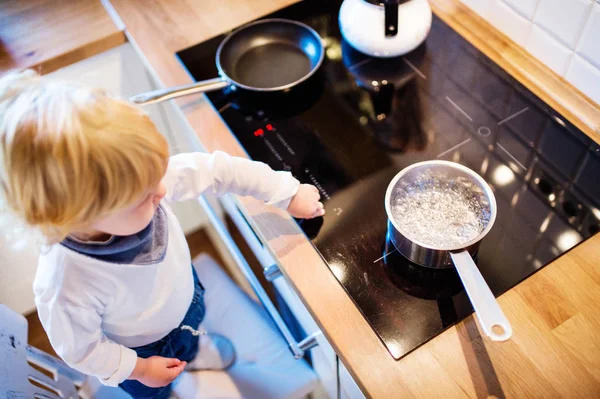 Toddler boy in dangerous situation at home. Child safety concept. — Stock Photo, Image