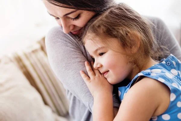 Jovem mãe com uma menina pequena em casa . — Fotografia de Stock