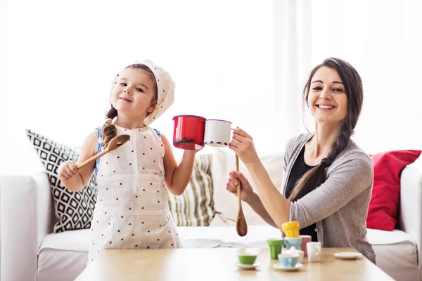 Ung mamma med en liten flicka hemma, spelar. — Stockfoto