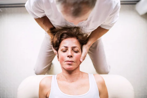 Fisioterapista senior che lavora con una paziente donna. Vista dall'alto . — Foto Stock