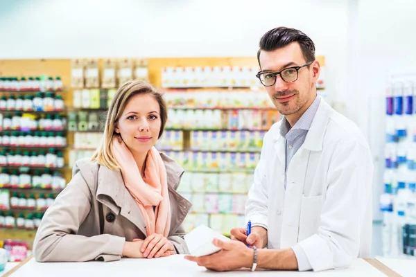 Portret męski farmaceuty z klientem kobiece. — Zdjęcie stockowe